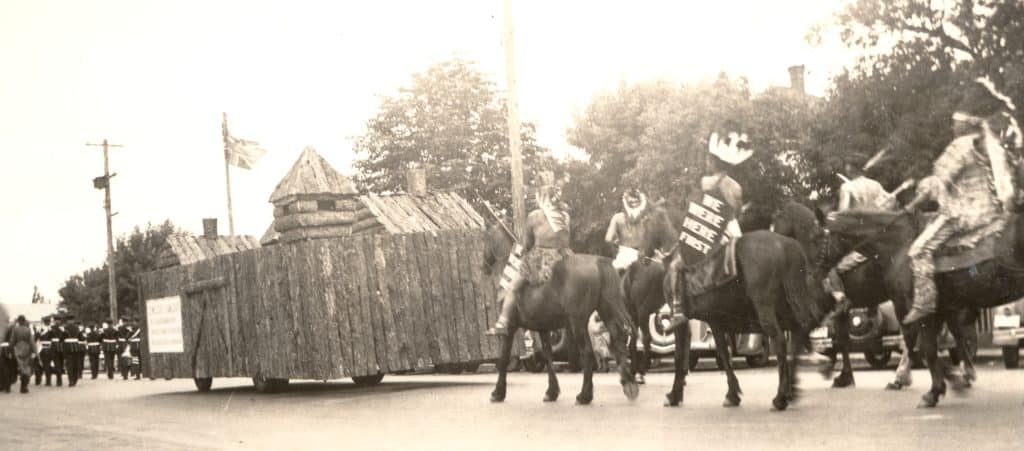 Tk’emlups te Secwepemc members ride on horseback carrying shields emblazoned with the message "we were here first" behind a replica of Fort Thompson in the city’s 1937 Dominion Day parade