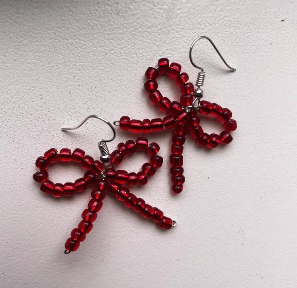 Bow earrings made with red beads. 