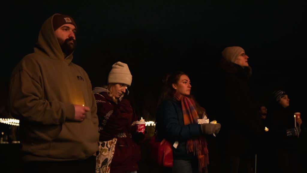 Kamloops community vigil for Muhammad “Ash” Zafar, where folks are holding candles together and watching the speech.