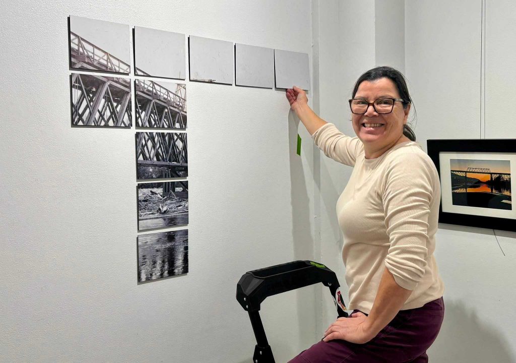 The DIS//CONNECT exhibition features art of all mediums. These photo has Rush hanging one of the art. Red Bridge exhibition