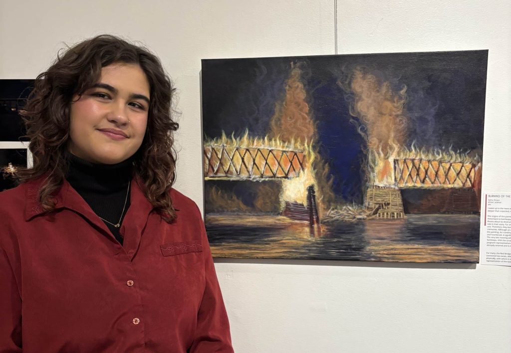The DIS//CONNECT exhibition features art of all mediums. These photo has Sirianni posing with her art. Red Bridge exhibition