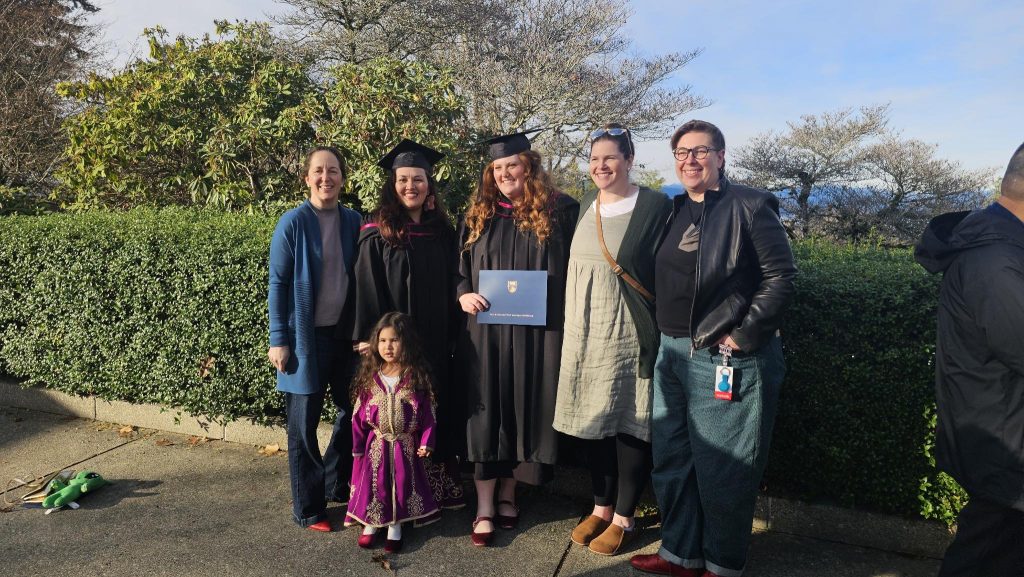 A group of people pose outdoors at UBC graduation